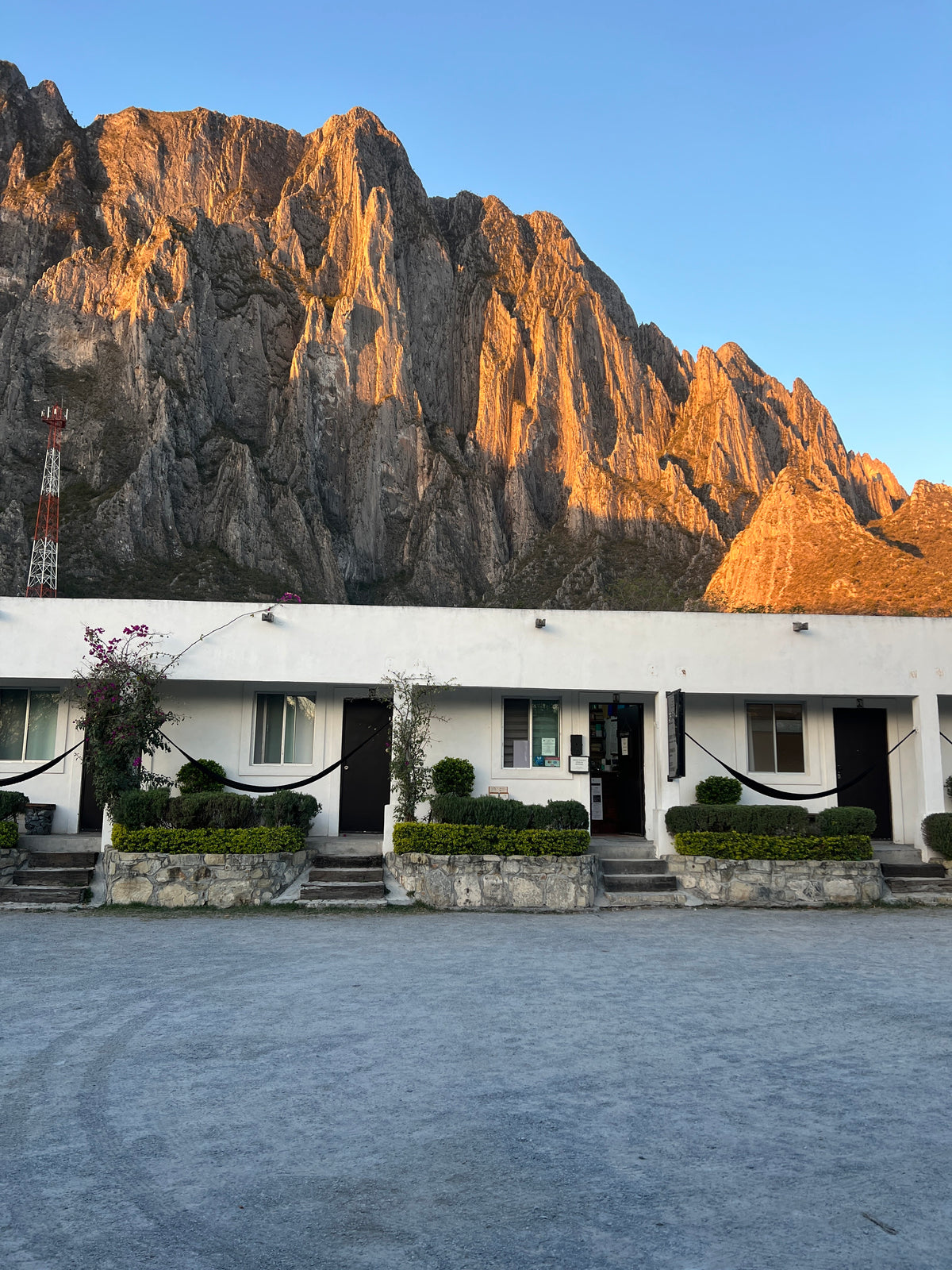 La Posada rooms and hammocks beneath sunlit limestone cliffs